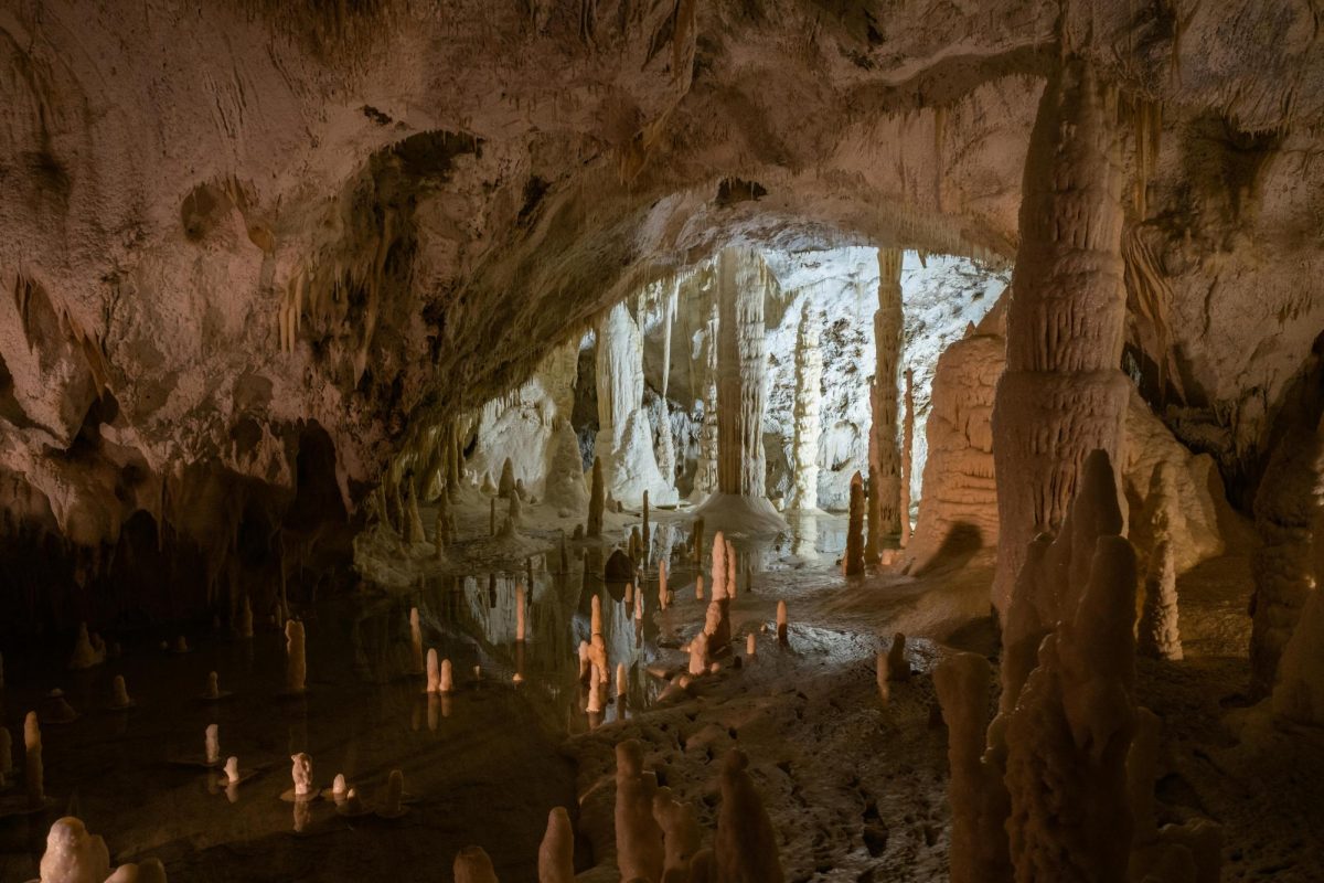 Tunnel in a Dark Cave with Stones and Water